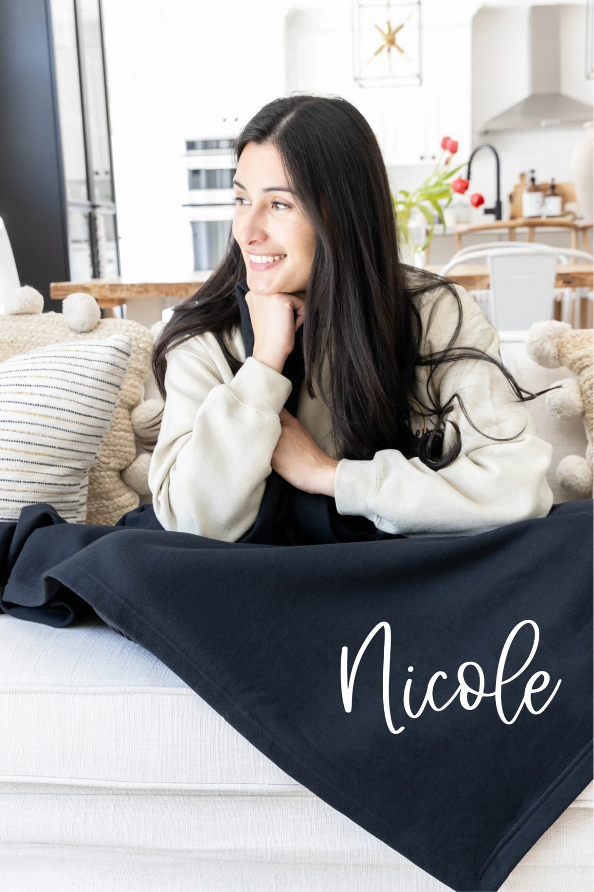 woman with a black monogrammed blanket draped over her legs