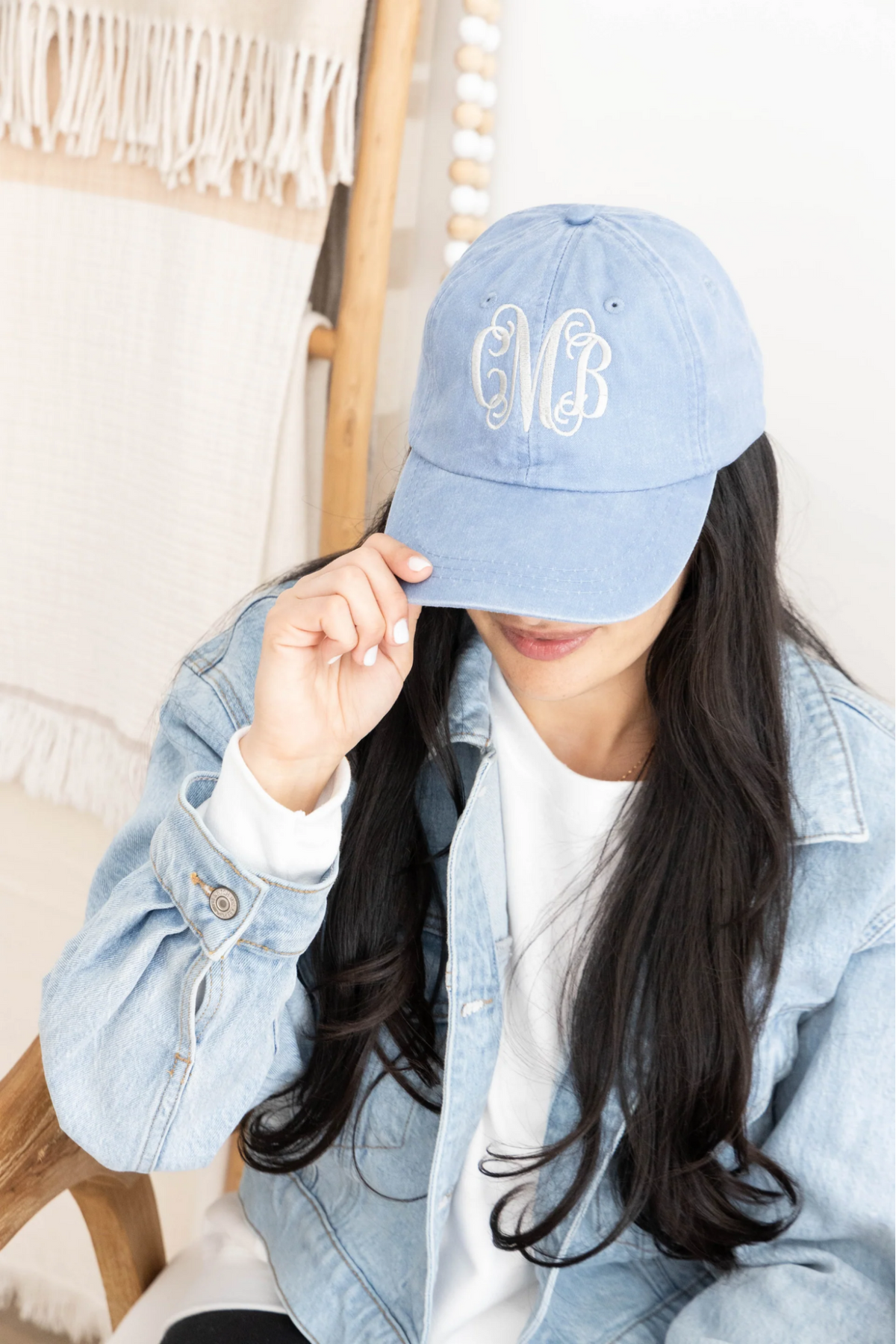 woman wearing a blue monogrammed baseball hat