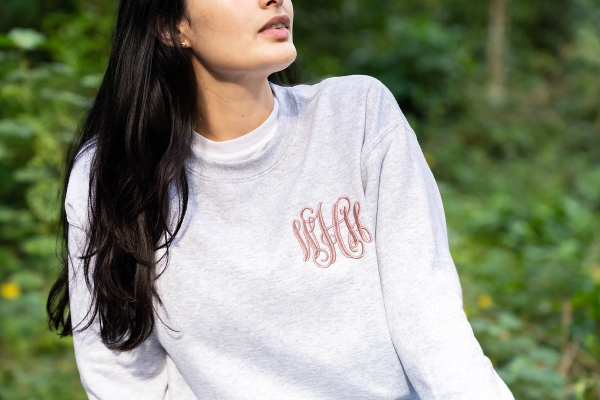woman wearing a gray monogram sweatshirt