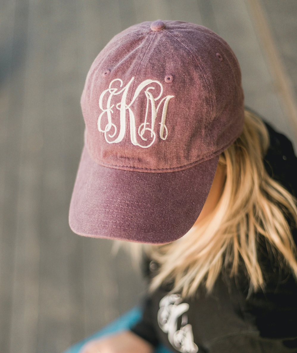 woman wearing a maroon monogrammed hat