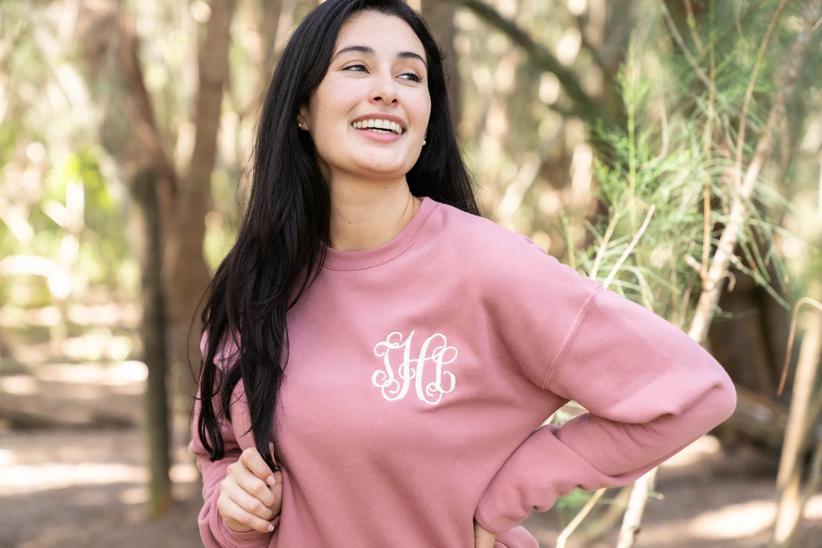 woman standing outside in a pink monogrammed sweatshirt